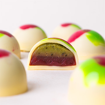 Praline mit Matcha- und Himbeer-Geschmack aus wei&szlig;er belgischer Schokolade