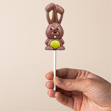 Gr&uuml;ner Schokoladenhase zu Ostern, in der Hand pr&auml;sentiert