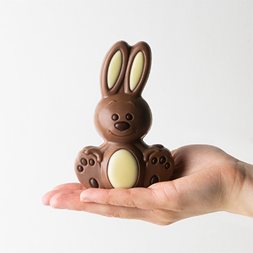 Osterhase aus belgischer Schokolade auf der Handfläche präsentiert