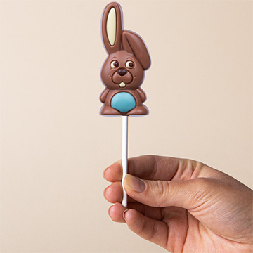 Blauer Schokoladenhase zu Ostern, in der Hand pr&auml;sentiert