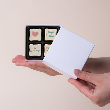 Satz von 4 personalisierten Pralinen mit Walnussfüllung für eine Hochzeit auf der Hand präsentiert