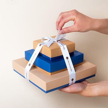 Assortierte Schokoladenbonbons mit Pralinen, gebunden mit einem Band für ein Geschenk in den Händen