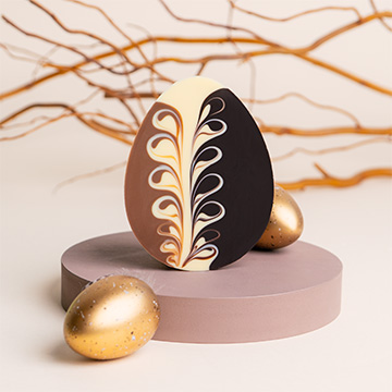 Dekoratives Muster auf dem flachen Ei aus 3 Sorten Schokolade zu Ostern
