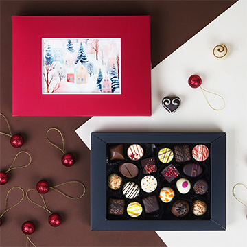 Ein Set aus 20 Pralinen in einer roten Verpackung mit Ihrem eigenen Foto in einem weihnachtlichen Arrangement