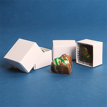 Herzförmige Pralinen in einer dekorativen weißen Schachtel