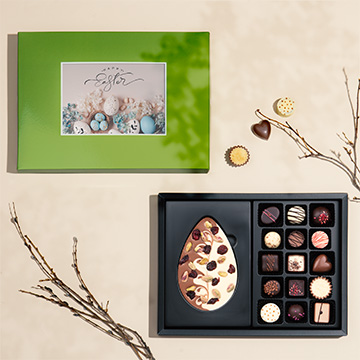 Osterpralinen-Set mit einer Schokoladen-Osterei, reich verziert mit zusätzlichen Zutaten