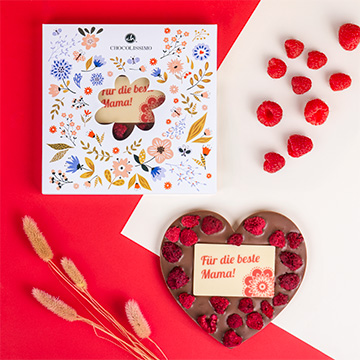 Schokoladenherz mit Himbeeren für Mama in einer dekorativen Schachtel