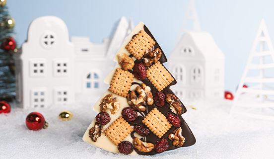 Toppings in einen belgischen Schokoladenweihnachtsbaum getaucht