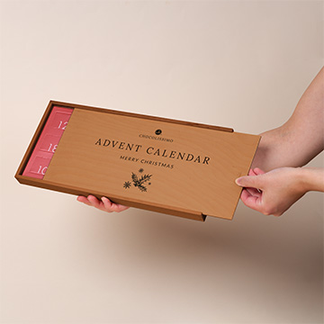 Präsentation des Adventskalenders in einer Holzbox mit Neapolitanern in den Händen