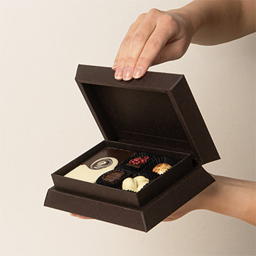 ein Set Pralinen aus belgischer Schokolade in den Händen präsentiert