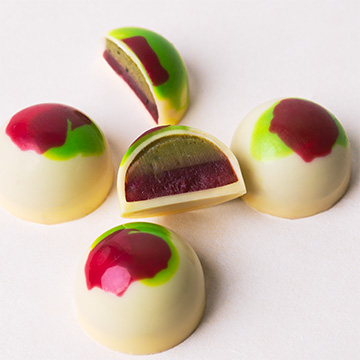 Handgefertigte Pralinen aus wei&szlig;er belgischer Schokolade mit Matcha-Himbeer-F&uuml;llung