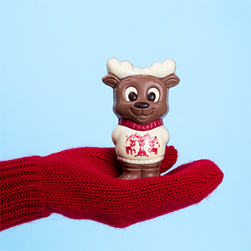 Schokoladenfigur eines Renifers in einem weißen Pullover
