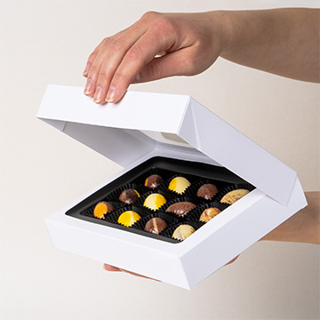 Pralinen in Form von Ostereiern in einem Osterset, das in den Händen gehalten wird