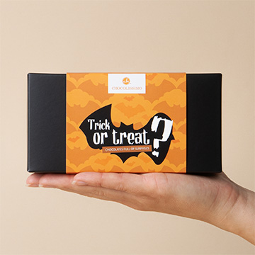 eine Schachtel mit 3 Schokoladen-Halloween-Fledermäusen auf einer Hand präsentiert