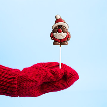 Der Weihnachtsmann wird in Form eines Lutschers in der Hand präsentiert