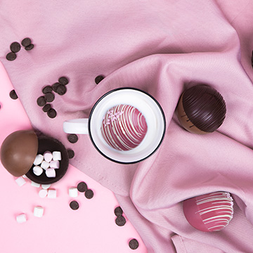 Schoko-Rubbelkugel mit Marshmallows neben der Verpackung