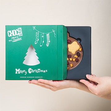 Weihnachtskugel aus Schokolade in den Händen