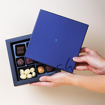 Set von Weihnachtsbonbons aus belgischer Schokolade in der Hand präsentiert