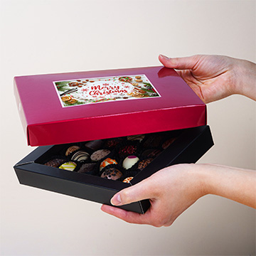 Dekorative Weihnachtspostkarte Box Grand rot in den Händen präsentiert