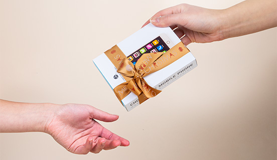 Übergabe der dekorativen Verpackung eines Schokoladen-Smartphones
